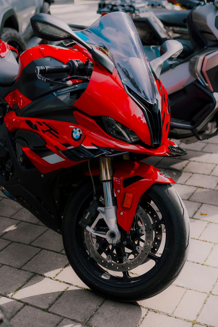 services-01 Vibrant red BMW motorcycle parked on outdoor pavement, showcasing a modern design.